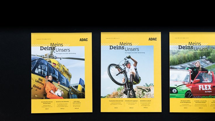 VISUELL Kommunikationsdesign: Editorial Design ADAC Württemberg e.V.: Drei verschiedene Ausgaben nebeneinander auf schwarzem Hintergrund