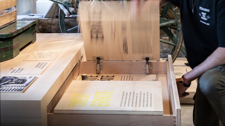 VISUELL Szenografie: Obstbaumuseum: Besucher nutzt die beweglichen Informationsplatten der ausgezogenen Schublade
