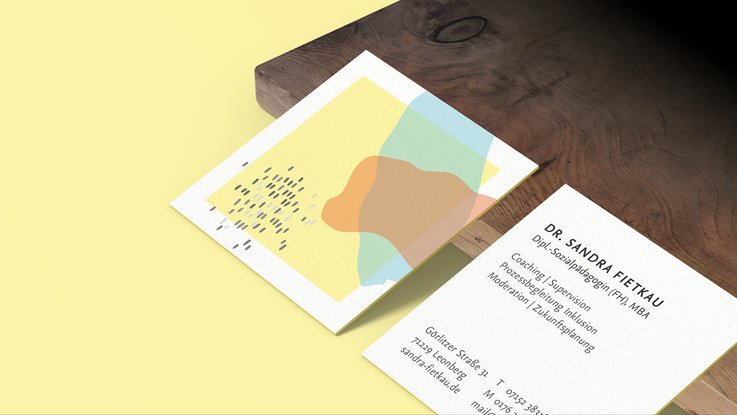 VISUELL Kommunikationsdesign: Visual Identity: quadratische Visitenkarte mit gelbem Rand an der Visitenkarte. Darauf ein gelbes Quadrat und ein rotes, sowie blaues organisches Farbfeld, sowie graue vereinzelte Punkte  