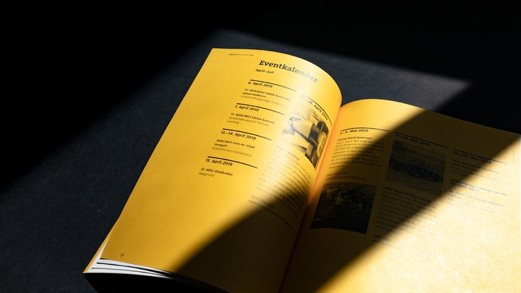 VISUELL Kommunikationsdesign: Editorial Design ADAC Württemberg e.V.: Gelbe Innenseiten mit Text mit Schattenwurf. - Aufschrift: Eventkalender
