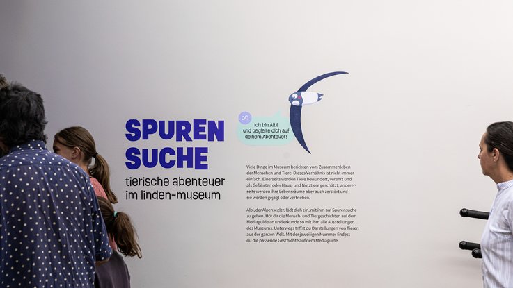 VISUELL Szenografie: Ausstellung „Spurensuche“: Wandbeschriftung zu Beginn der Ausstellung - Aufschrift: Spurensuche. Tierische Abenteuer im Linden-Museum