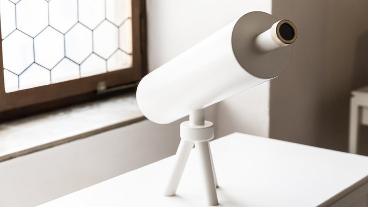 VISUELL Szenografie: Medienstation – ein weißes Teleskop auf einem Tisch