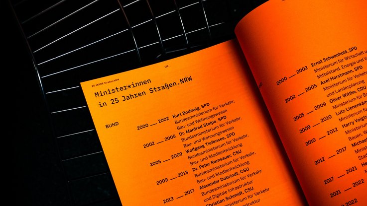VISUELL Kommunikationsdesign: Jubiläumsbroschüre Straßen.NRW VISUELL Kommunikationsdesign: Jubiläumsbroschüre Straßen.NRW: Aufgeschlagene orangefarbene Doppelseite der Jubiläumsbroschüre mit einer chronologischen Übersicht der zuständigen Minister:innen in Bund und Land während 25 Jahren Straßen.NRW.
