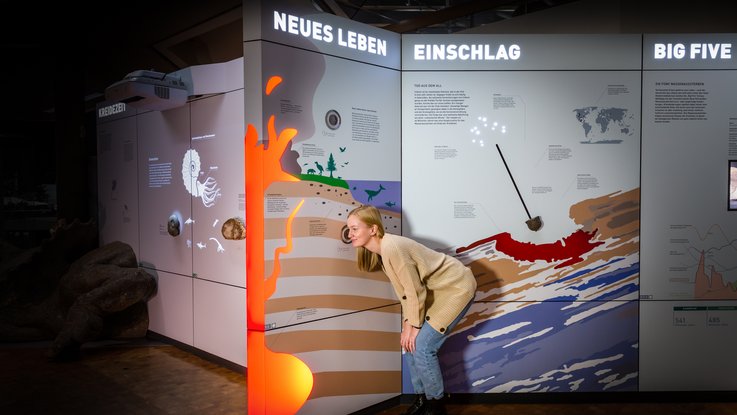 VISUELL Szenografie: Naturkundemuseum: Besucher nutzt die Hörstation wie sich die Welt damals angehört haben könnte
